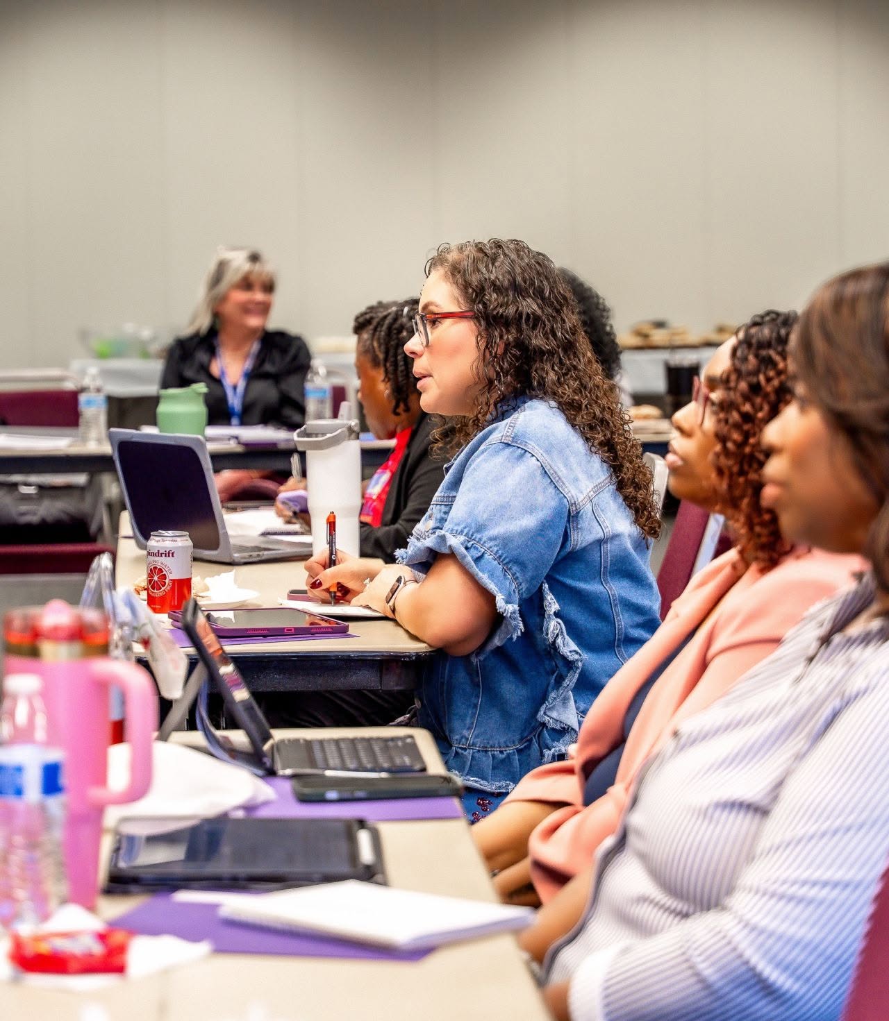 A B.I.D. Academy participant asking a question during class while others listen.