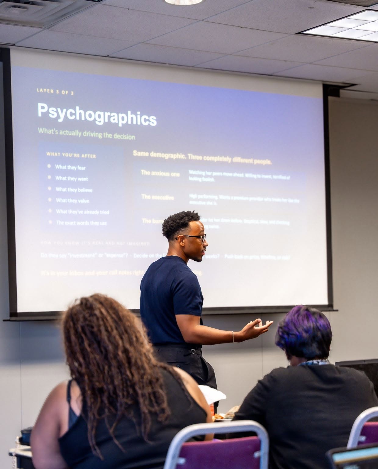 A facilitator presenting a slide titled Psychographics, what's actually driving the decision, to B.I.D. Academy participants.